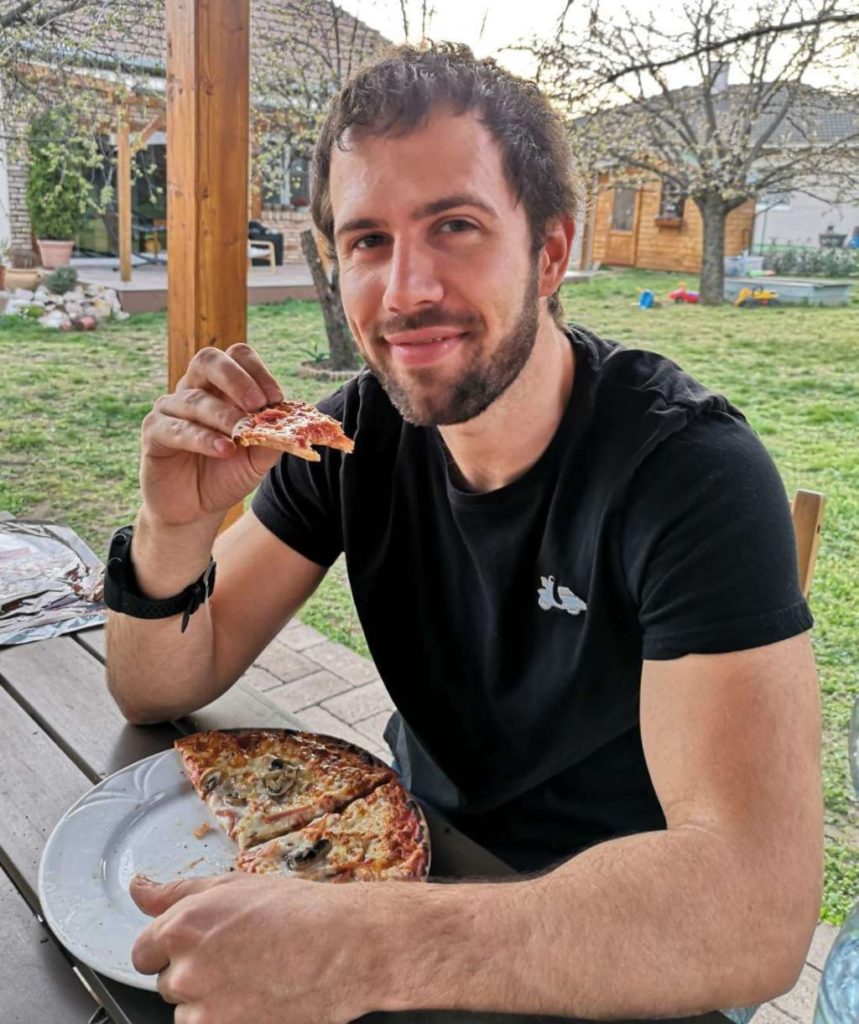 HunFun Founder Daniel eats pizza in nice Hungarian garden